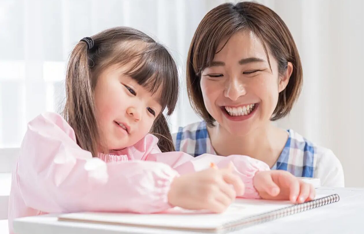 ノートに書き込む子どもと母親